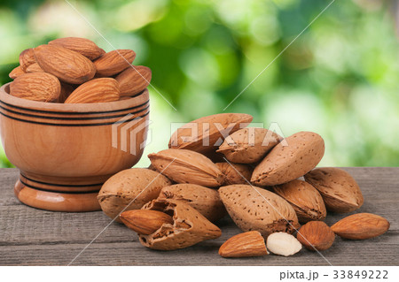 almonds in a bowl on the old wooden board with almonds in a bowl on the old wooden board with 33849222
