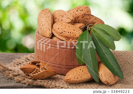almonds with leaves in a bowl on the old wooden almonds with leaves in a bowl on the old wooden 33849223