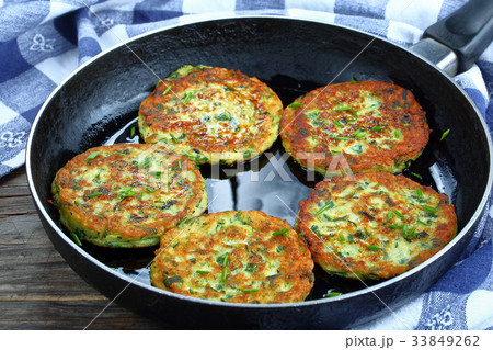 zucchini fritters on skillet, top view 33849262