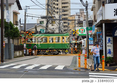 江の島駅脇の踏切を通過する江ノ電の写真素材