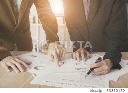 hand pointing at graph document during discussion  33850120