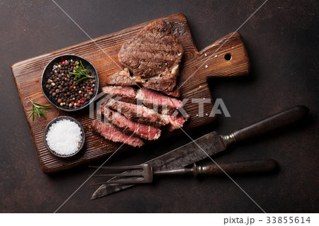 Grilled beef steak with spices on cutting board Grilled beef steak with spices on cutting board 33855614