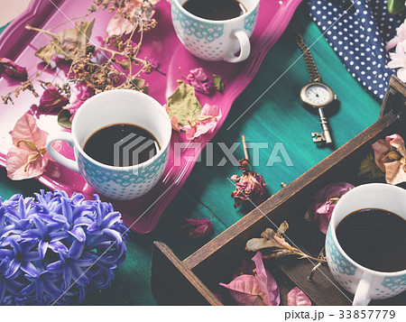 Coffee and flowers on dark background Coffee and flowers on dark background 33857779