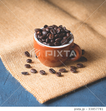 Coffee beans in espresso cup on burlap Coffee beans in espresso cup on burlap 33857781