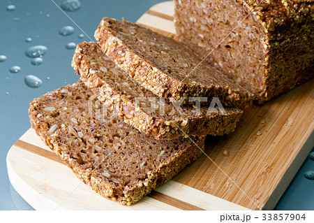 Loaf of wholegrain bread and slices on wooden 33857904