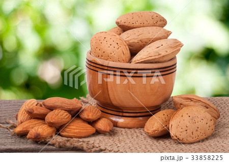 almonds in a bowl on the old wooden board blurred almonds in a bowl on the old wooden board blurred 33858225
