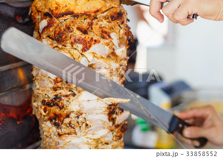 Shawarma meat being cut 33858552