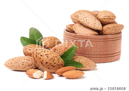 Almonds in a wooden bowl with leaves isolated on 33858608