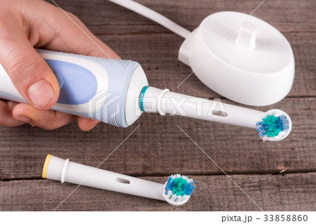 Electric Toothbrush in hand on an old wooden 33858860