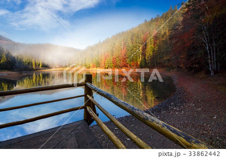 wooden pierce fence on a lake in fog wooden pierce fence on a lake in fog 33862442
