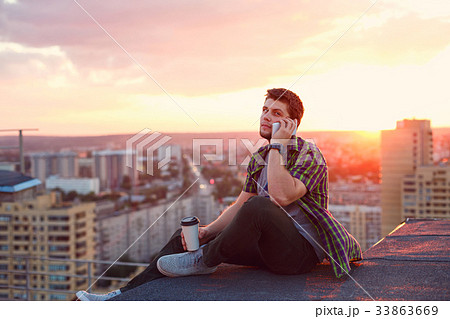 Man drinking coffee and talking on phone Man drinking coffee and talking on phone 33863669