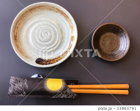 ceramic dish (plate) and chopsticks on black table 33863791