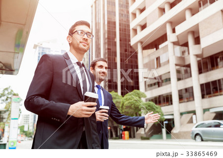 Two young businessmen hailing for a taxi 33865469