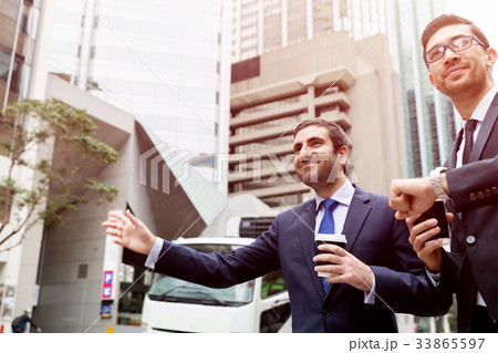 Two young businessmen hailing for a taxi 33865597