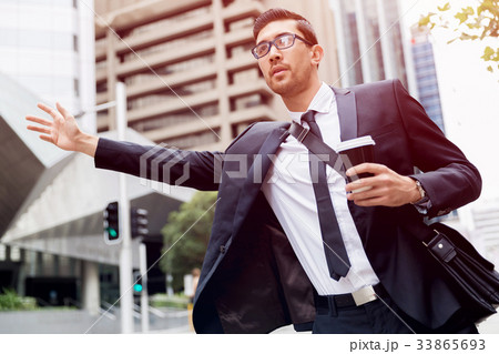 Young businessmen hailing for a taxi 33865693