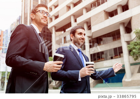 Two young businessmen hailing for a taxi Two young businessmen hailing for a taxi 33865795