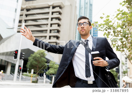 Young businessmen hailing for a taxi 33867895