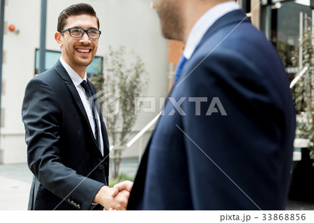 Two businessmen shaking their hands 33868856