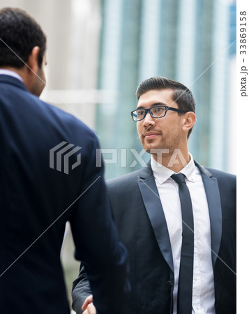 Two businessmen shaking their hands Two businessmen shaking their hands 33869158