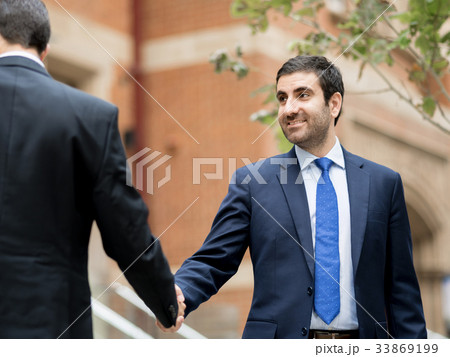 Two businessmen shaking their hands 33869199
