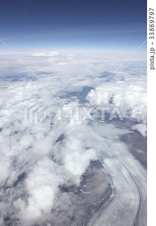 雲海の雲間から見える真夏の北極圏 アラスカの凍結した白銀の川の写真素材