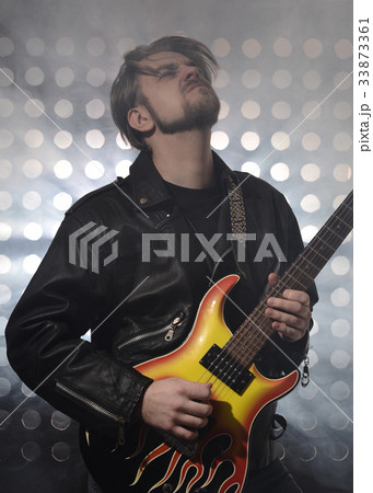 rock guitarist playing electric guitar in fog 33873361