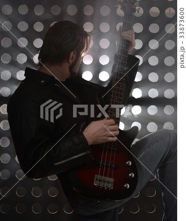 Bassist playing bass guitar in smoke. backlight 33873600