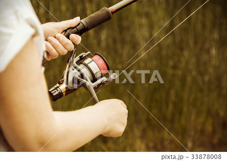 female hands holding a fishing rod feeder female hands holding a fishing rod feeder 33878008