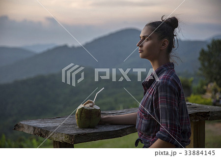 Hipster young girl with coconut enjoying sunset Hipster young girl with coconut enjoying sunset 33884145