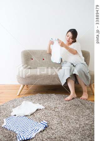 ベビー服を見る妊婦さん ベビー服を見る妊婦さん 33889479
