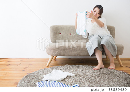 ベビー服を見る妊婦さん ベビー服を見る妊婦さん 33889480