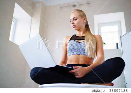 Sports girl with laptop in lotus pose 33895188