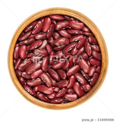 Dried red kidney beans in wooden bowl over white 33896986