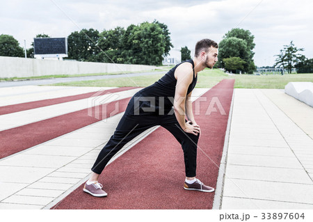 Athlete preparing for training on running track Athlete preparing for training on running track 33897604