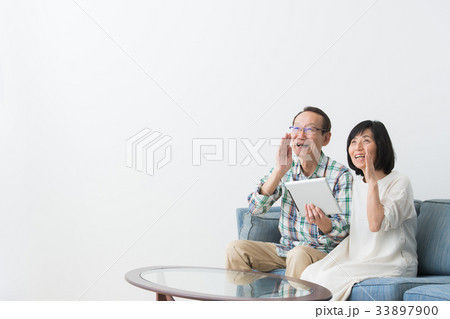 タブレット機器を操作する男女　シニア 33897900