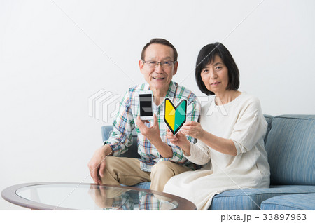 スマホを持つシニア夫婦 スマホを持つシニア夫婦 33897963