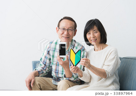 スマホを持つシニア夫婦 スマホを持つシニア夫婦 33897964