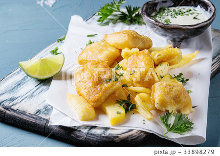 Fish and chips with sauce 33898279