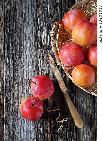 Red plums in wicker basket 33901017