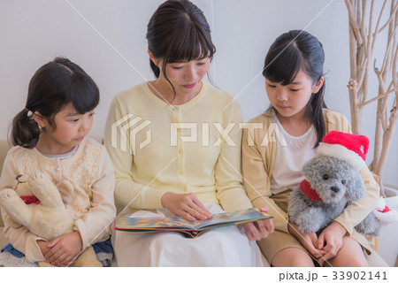 クリスマスの本を読む母と娘、ソファーに座った親子、幸せ家族、あったか家族、ソファーに座った家族 クリスマスの本を読む母と娘、ソファーに座った親子、幸せ家族、あったか家族、ソファーに座った家族 33902141