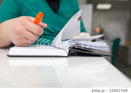 The doctor writes in a notebook at the clinic The doctor writes in a notebook at the clinic 33902506