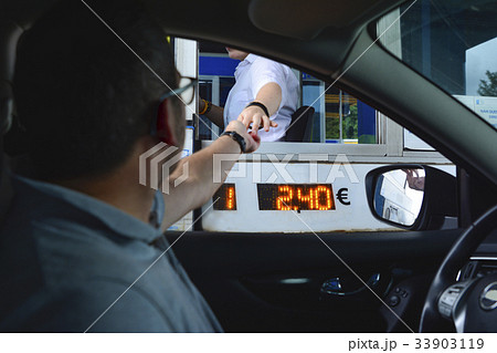 A man pays money to a cashier for a toll road 33903119