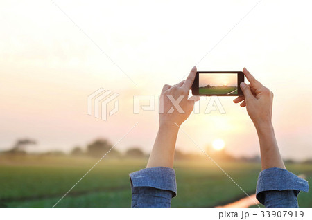 Woman taking photo  in sunset, relax time in rural 33907919