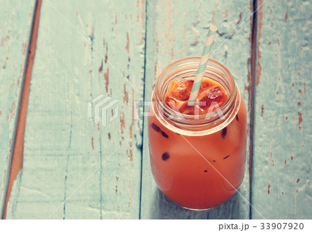 Milk tea with ice on wooden background Milk tea with ice on wooden background 33907920