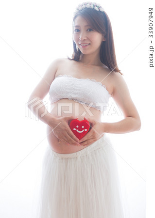 ハートのぬいぐるみを持つドレス姿の妊婦さん ハートのぬいぐるみを持つドレス姿の妊婦さん 33907949