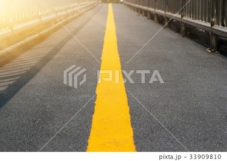 Asphalt perspective yellow road line, soft focus 33909810