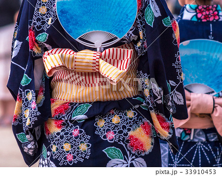 夏の盆踊りで踊る、カラフルな浴衣を着た女性達 夏の盆踊りで踊る、カラフルな浴衣を着た女性達 33910453