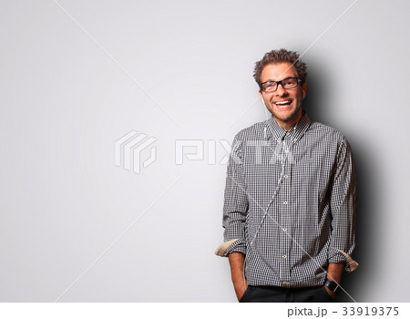 Young man in a cellular shirt is smiling 33919375