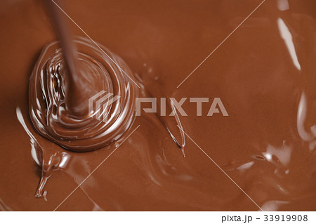 pouring melted premium dark chocolate from above pouring melted premium dark chocolate from above 33919908