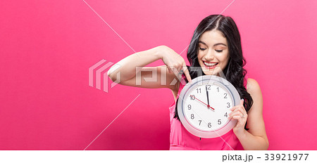 Woman holding clock showing nearly 12 33921977